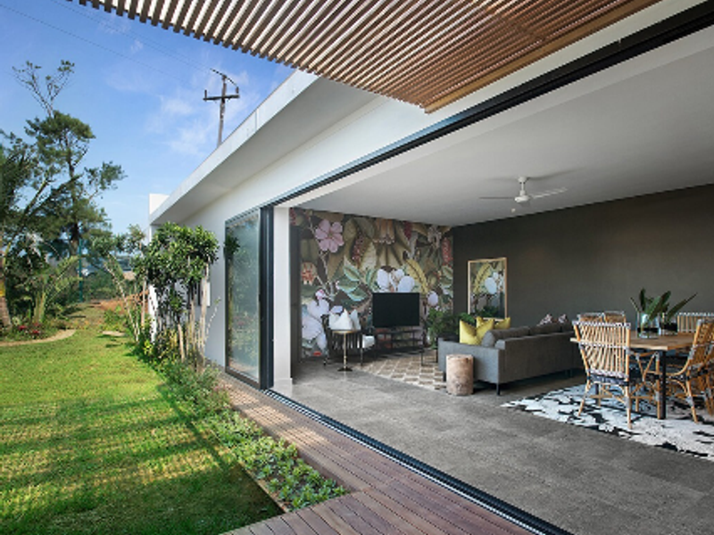 Spacious open-plan living and dining area featuring large sliding glass doors that open onto a timber deck and garden.