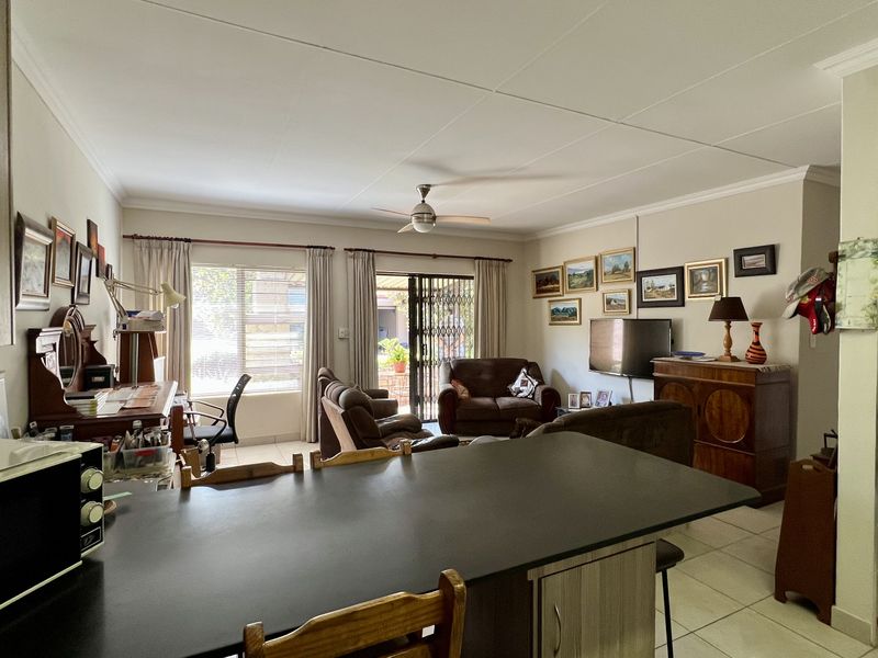 Open-plan living and kitchen area featuring tiled floors, a central island, and sliding door access to the outdoor patio.