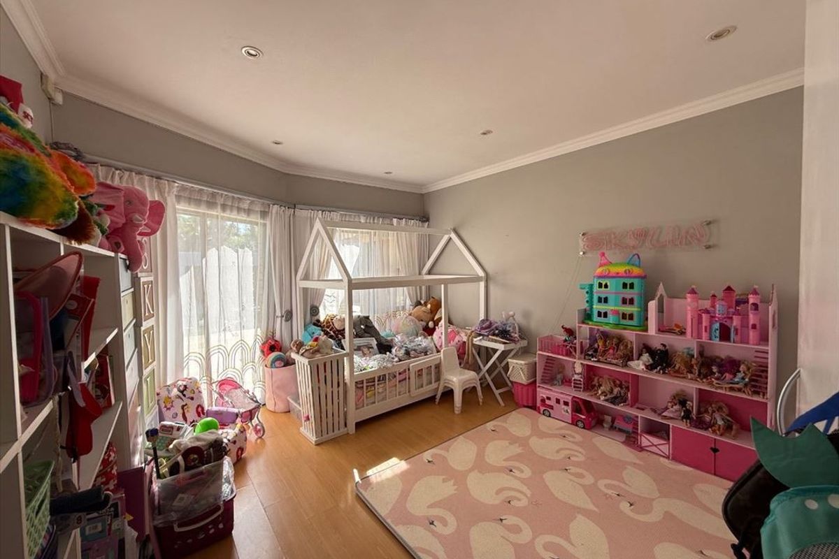 A bedroom featuring laminate flooring, recessed downlighting, and a sliding glass door providing access to the exterior.