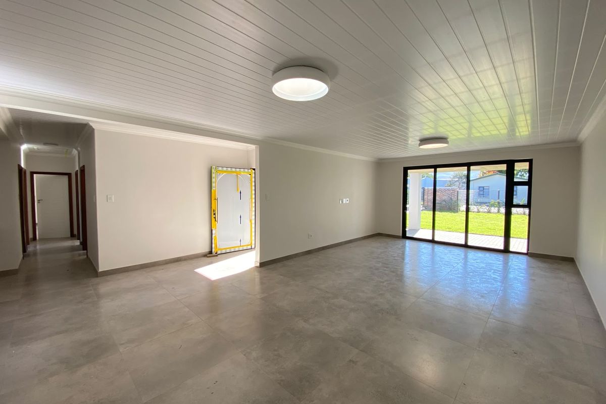 Spacious, light-filled open-plan living area featuring large sliding glass doors, modern tiled flooring, and a clean, neutral aesthetic ready for furnishing.