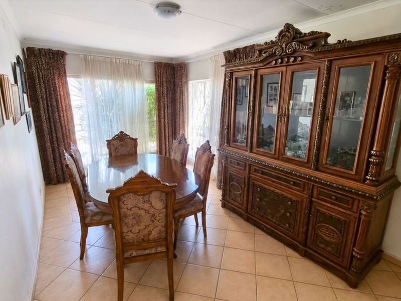 A dining room featuring tiled flooring and sliding glass doors that provide natural light.