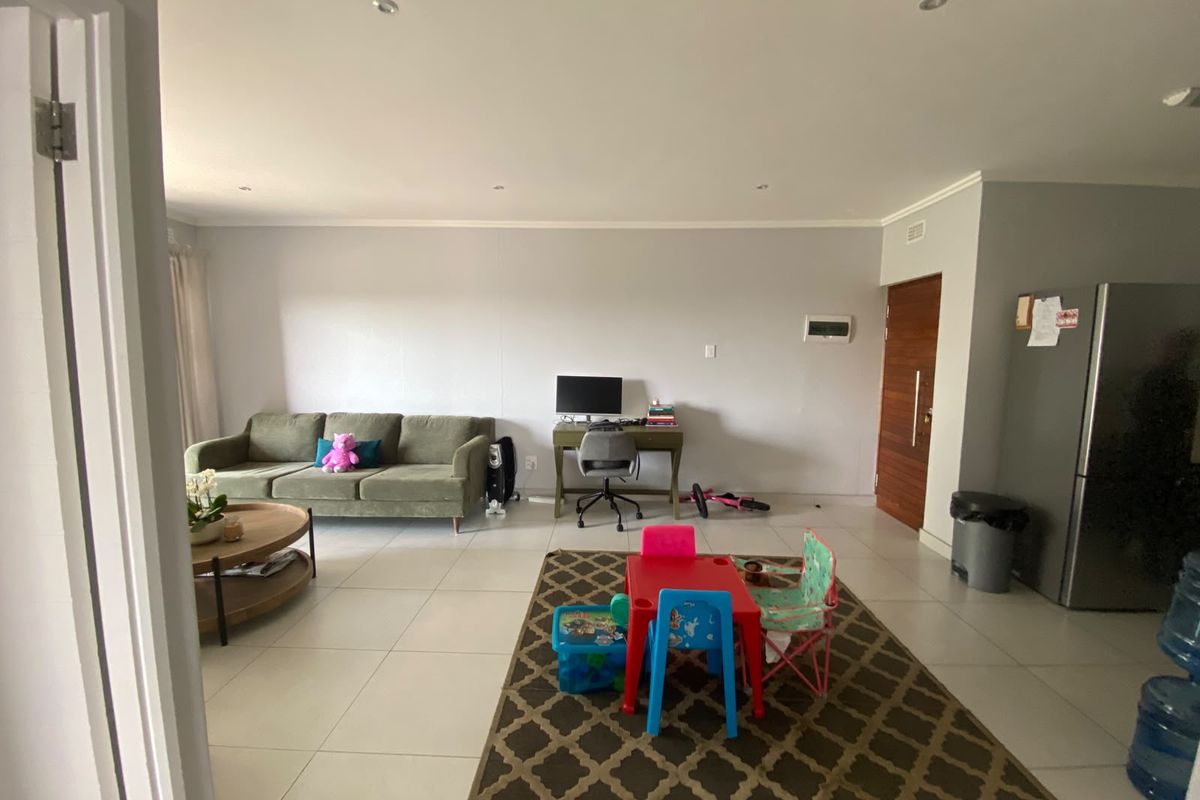 Spacious open-plan living area featuring neutral tiled flooring and recessed downlighting, providing a versatile layout for comfortable daily living.