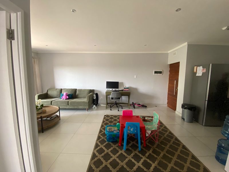 Spacious open-plan living area featuring neutral tiled flooring and recessed downlighting, providing a versatile layout for comfortable daily living.