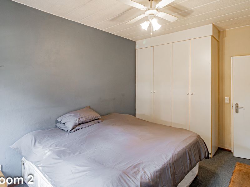 Bedroom featuring a built-in wardrobe, ceiling fan, and textured ceiling finish.