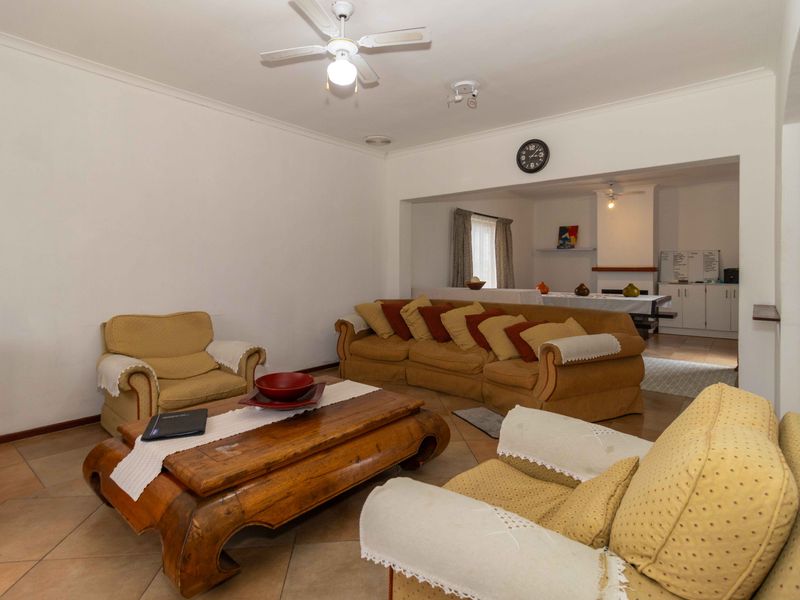 Open plan living and dining area featuring tiled flooring, a ceiling fan, and a fireplace in the adjacent space.