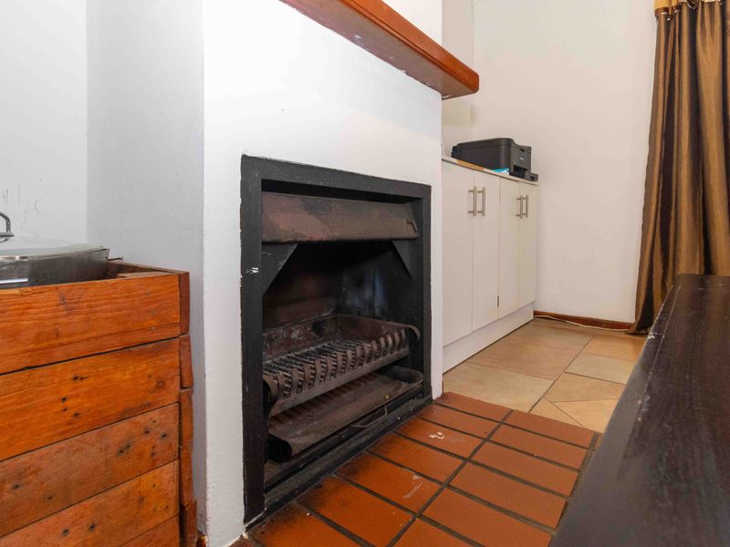 Living area featuring a built-in fireplace with a tiled hearth and adjacent built-in cabinetry.