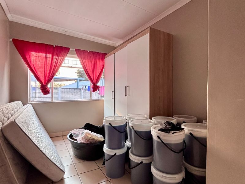 A bedroom featuring tiled flooring and a built-in wardrobe, offering a functional space ready for personalization.