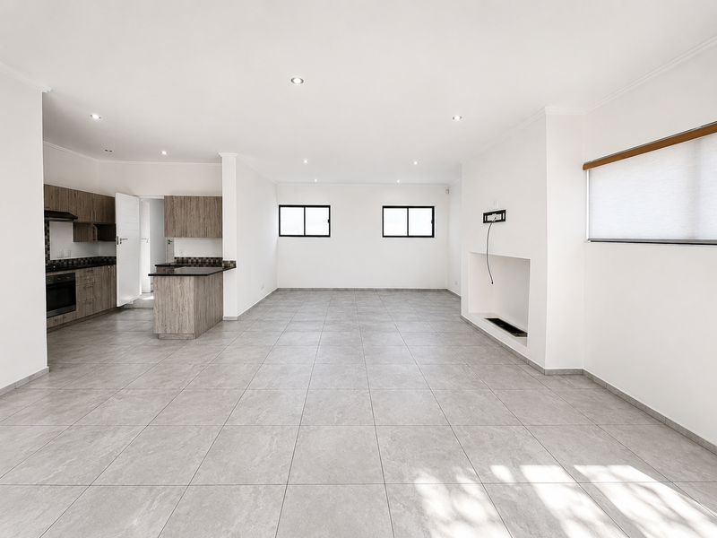 Spacious open-plan living area featuring tiled floors, recessed lighting, a built-in fireplace, and a modern kitchen with granite countertops and built-in appliances.