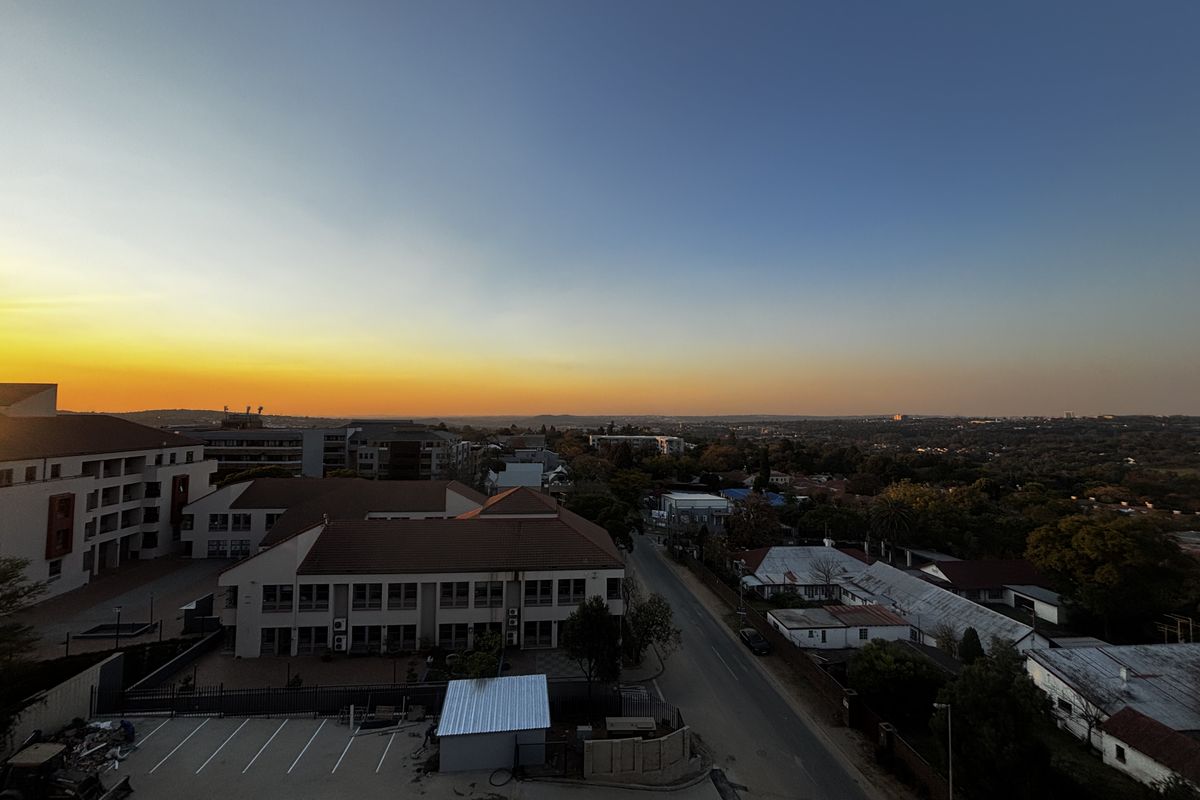 Elevated sunset view overlooking the surrounding neighborhood, urban landscape, and nearby residential and commercial buildings.