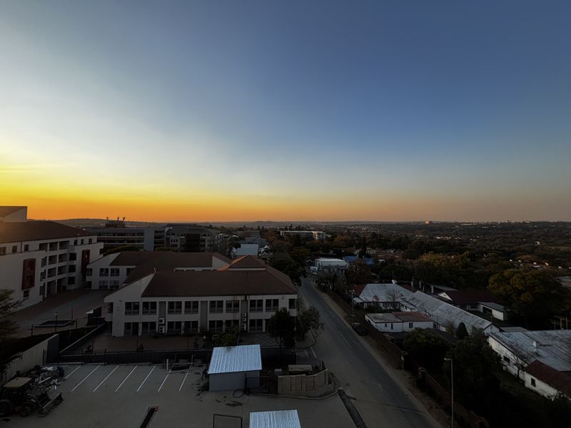 Elevated sunset view overlooking the surrounding neighborhood, urban landscape, and nearby residential and commercial buildings.
