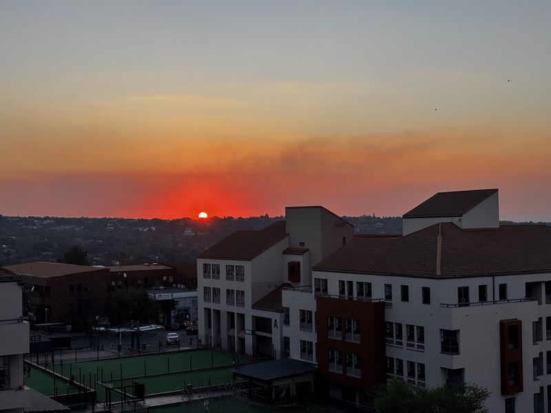 A scenic sunset view overlooking the surrounding urban landscape and apartment complex buildings.