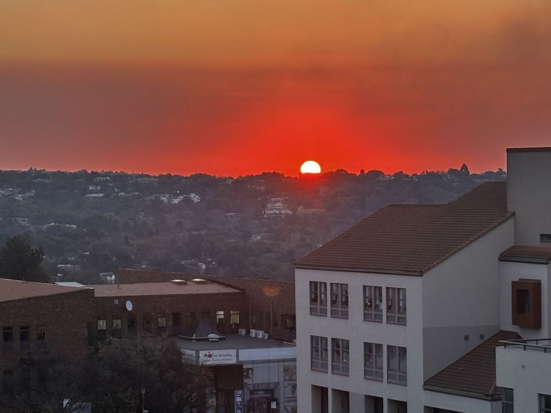 A scenic sunset view overlooking the surrounding neighborhood and urban landscape from an elevated vantage point.