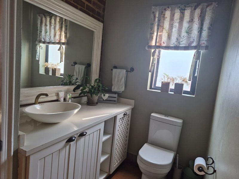 A well-maintained bathroom featuring a vessel sink, vanity cabinet, and an exposed brick accent wall, providing a charming and functional space.