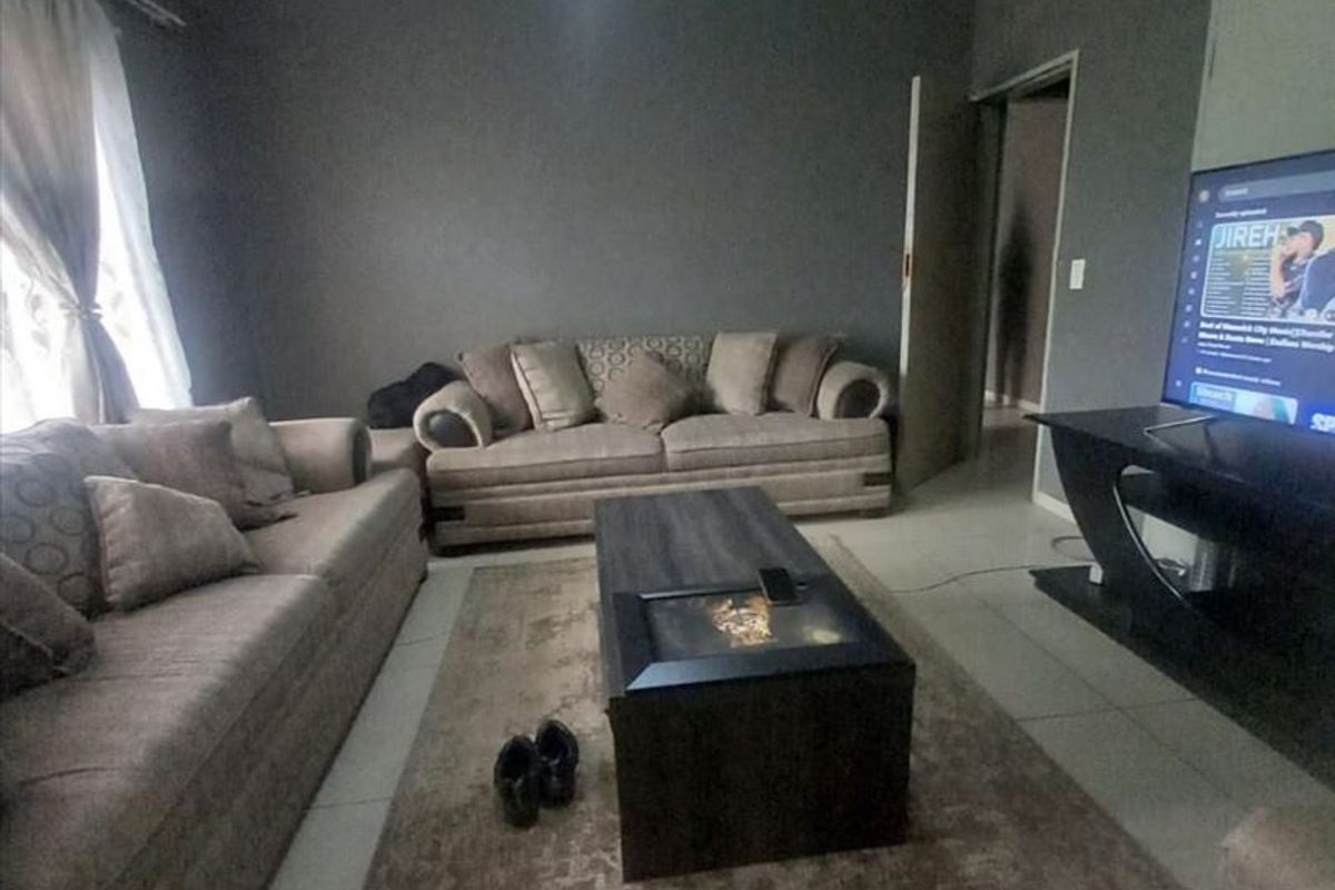 A living room featuring tiled flooring and ceiling molding, providing a neutral base for interior design updates.