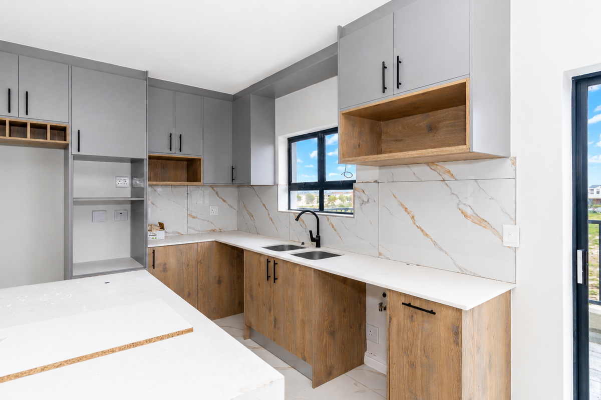 Modern kitchen featuring grey and wood-look cabinetry, marble-look splashback, stone countertops, and a double sink with a black mixer tap.