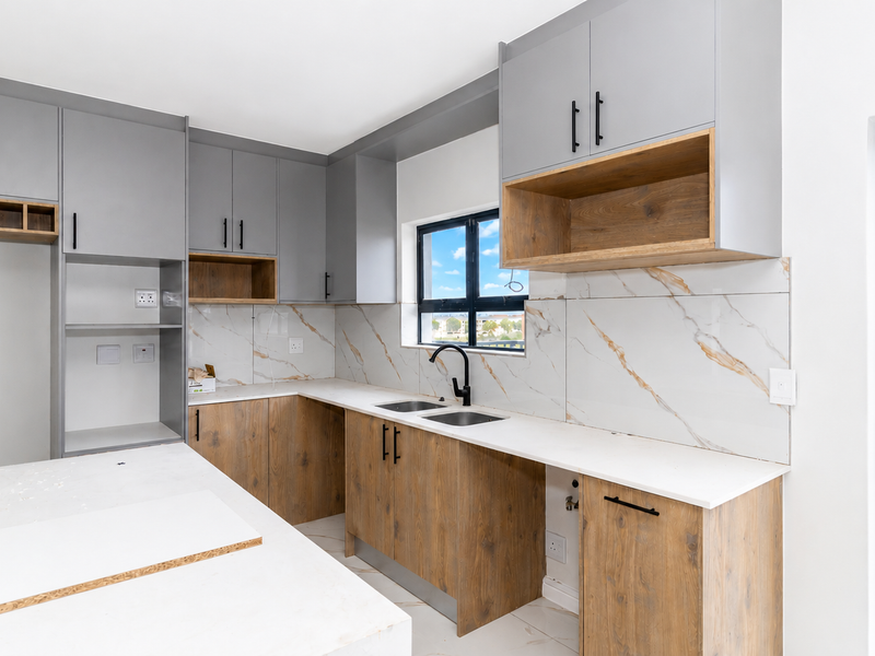 Modern kitchen featuring grey and wood-look cabinetry, marble-look splashback, stone countertops, and a double sink with a black mixer tap.