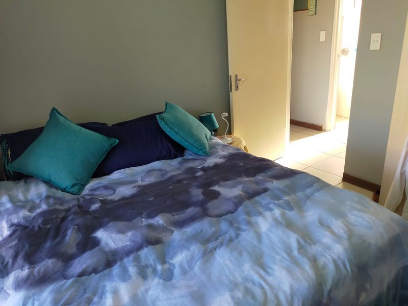 A bedroom featuring tiled flooring and an internal door leading to an adjacent space.
