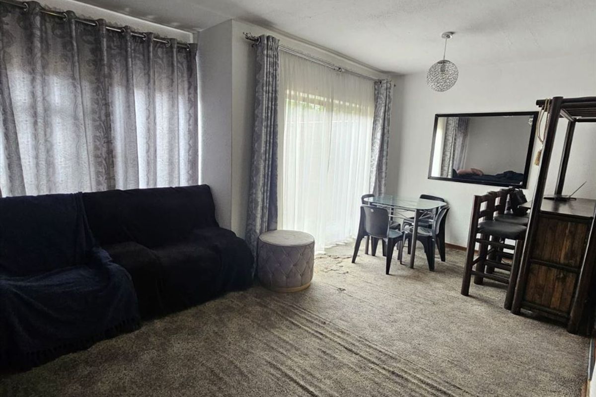 A living room area featuring fitted carpeting and a sliding glass door providing access to the exterior.