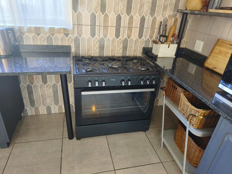 A functional kitchen area featuring a built-in gas stove and oven, complemented by granite countertops and decorative tiled backsplash.