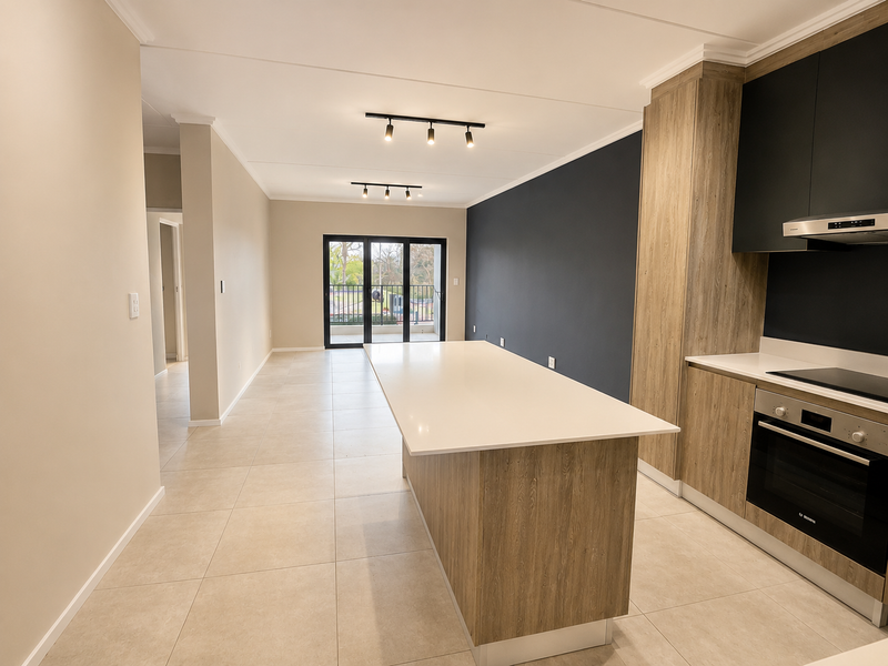 Modern open-plan living area featuring a sleek kitchen with stone island, built-in appliances, and large sliding doors leading to a balcony.