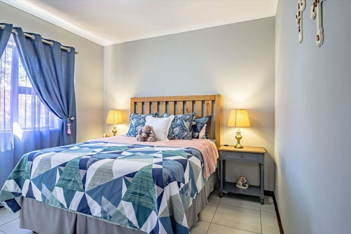 A well-maintained bedroom featuring neutral wall tones, tiled flooring, and decorative cove cornicing, providing a comfortable and functional living space.