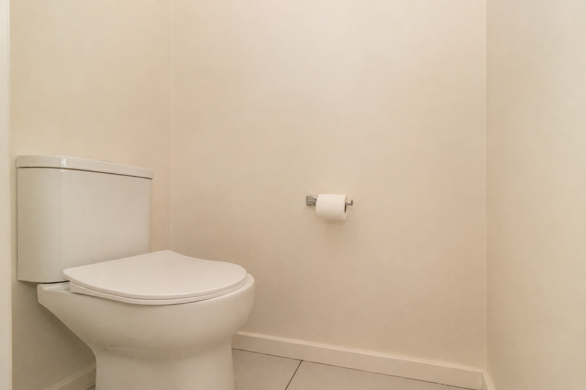 A clean and minimalist powder room featuring a modern white toilet and tiled flooring.