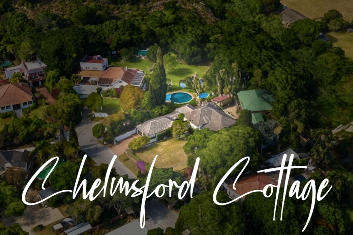Aerial view of Chelmsford Cottage property, showcasing the main residence, swimming pool, and surrounding landscaped grounds in a lush, wooded setting.