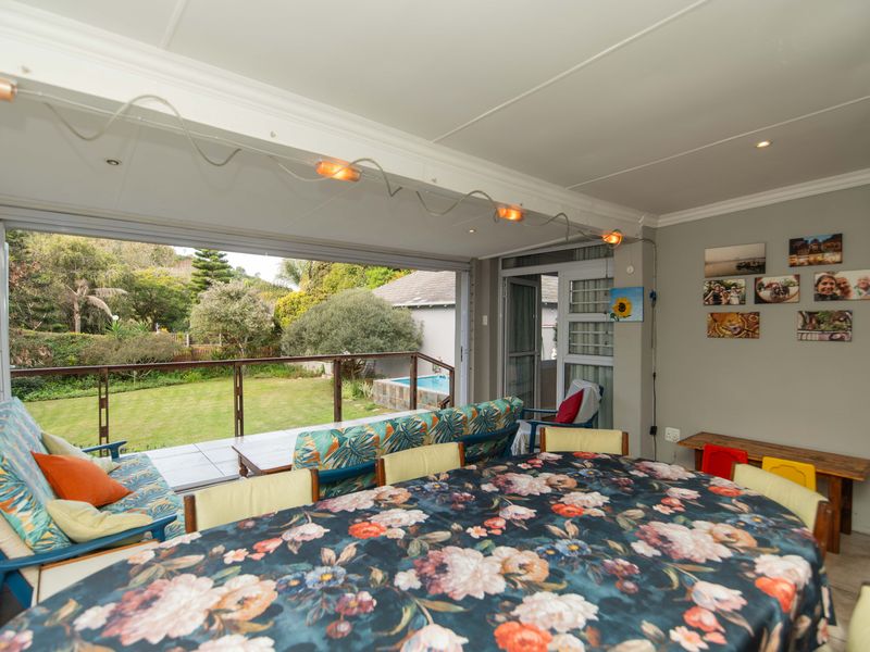 Open plan living area featuring large sliding glass doors that open onto a patio and garden, providing seamless indoor-outdoor flow.