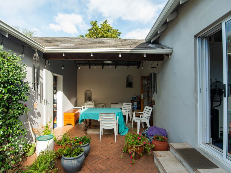 A covered outdoor patio area featuring brick paving and direct access to the home through a sliding glass door.