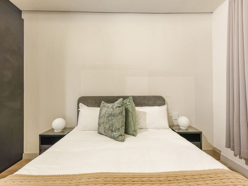 A well-maintained bedroom featuring a built-in wardrobe and neutral finishes, providing a clean and comfortable living space.
