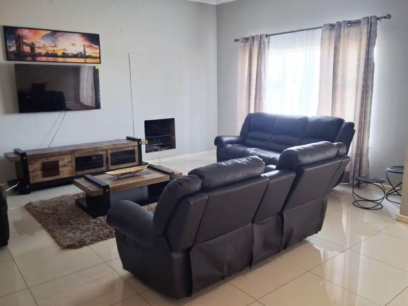A comfortable living room featuring tiled flooring and a built-in fireplace, providing a functional and inviting space for relaxation.