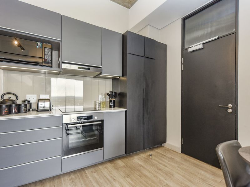 Modern kitchen featuring sleek grey cabinetry, integrated appliances including an oven and hob, and high-quality finishes throughout.
