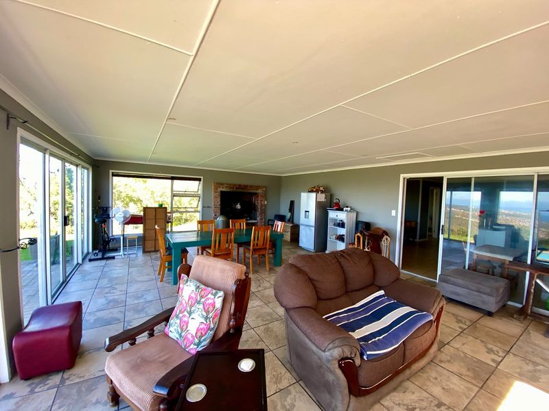 Spacious open-plan living and dining area featuring tiled flooring, a built-in brick fireplace, and large sliding glass doors with scenic views.