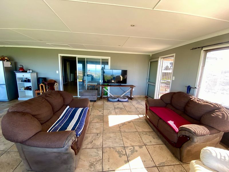 Spacious living room featuring tiled flooring, recessed lighting, and sliding glass doors providing access to the exterior and natural light.