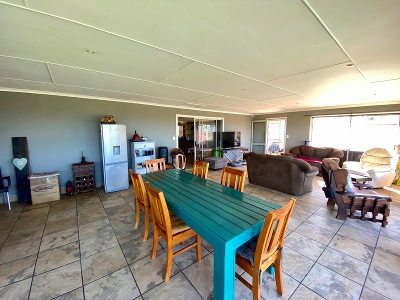 Spacious open-plan living and dining area featuring tiled flooring, recessed lighting, and large sliding glass doors providing access to the exterior.