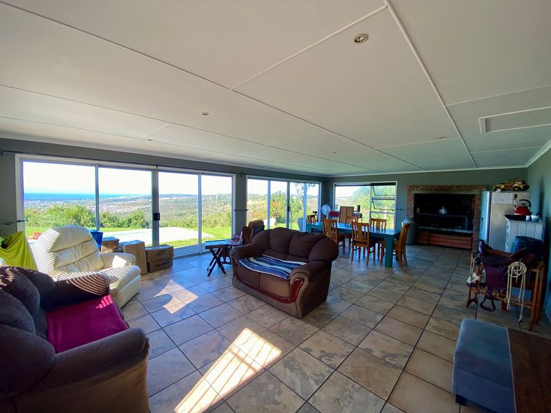 Spacious open-plan living and dining area featuring large sliding glass doors with panoramic landscape views and a built-in brick fireplace.