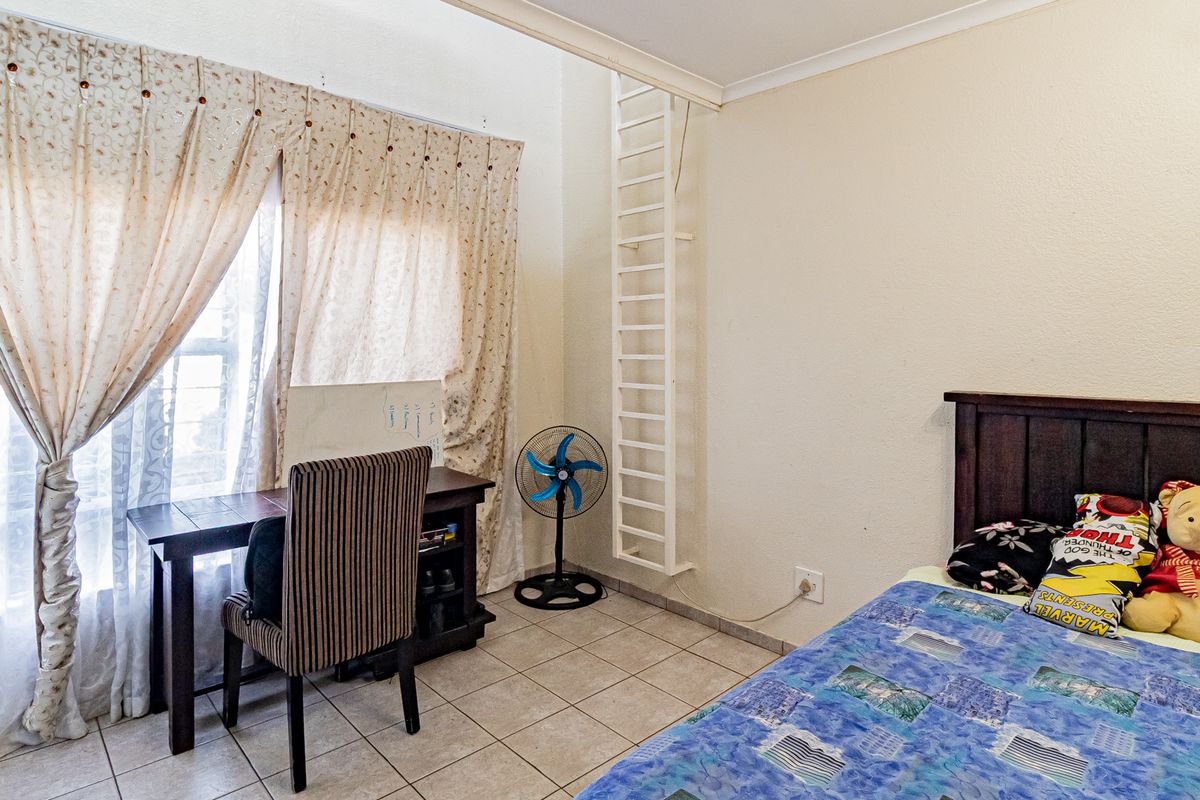 A bedroom featuring tiled flooring and a fixed ladder leading to an upper level, providing a functional and versatile living space.