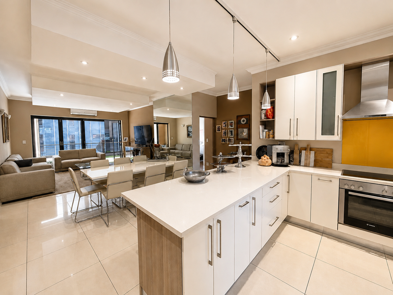 Modern open-plan living area featuring a sleek kitchen with quartz countertops, built-in appliances, and seamless flow to the dining and lounge space.