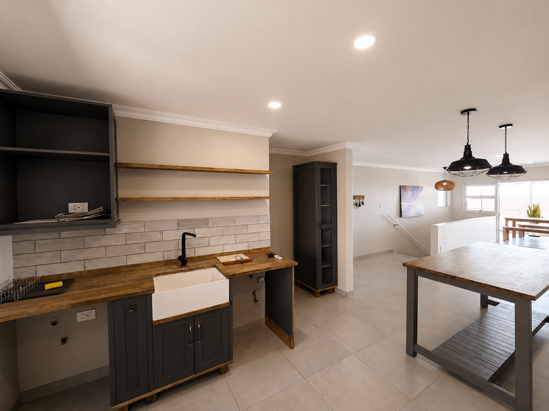 Modern kitchen featuring a farmhouse sink, wooden countertops, subway tile backsplash, and open shelving, seamlessly flowing into an open-plan living area.