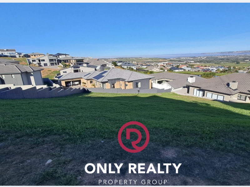 A view of the surrounding residential neighborhood and landscape from the elevated vacant land plot.