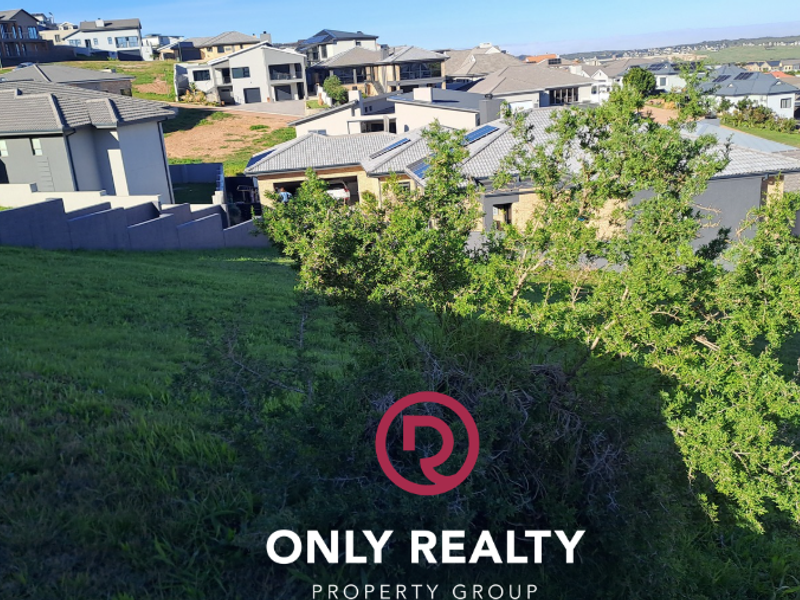 A view of the sloped residential land parcel overlooking the surrounding neighborhood and established housing development.
