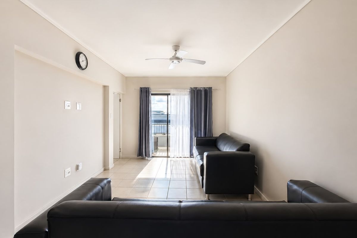 A bright living room featuring tiled flooring, a ceiling fan, and a sliding glass door providing access to an outdoor area.
