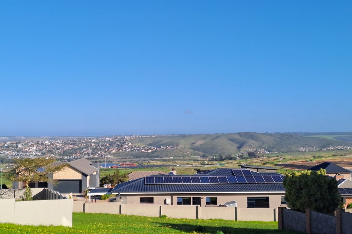 An elevated view overlooking a residential estate with surrounding hills and landscape in the distance.
