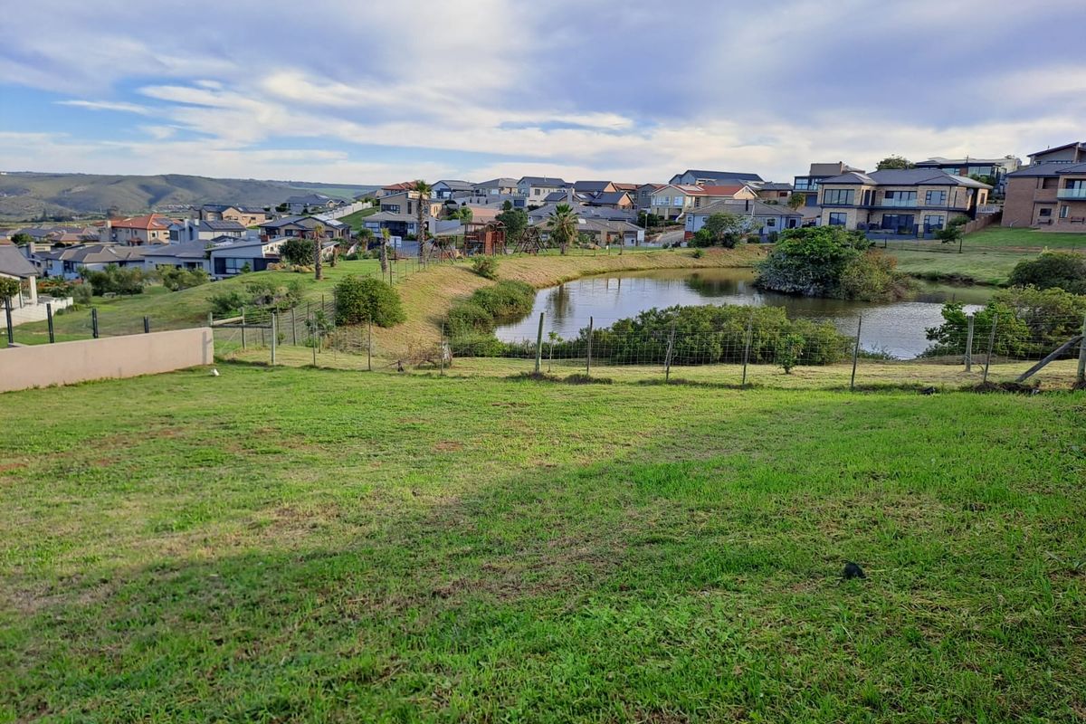A scenic view overlooking a residential estate pond and surrounding neighborhood landscape from the vacant residential land.