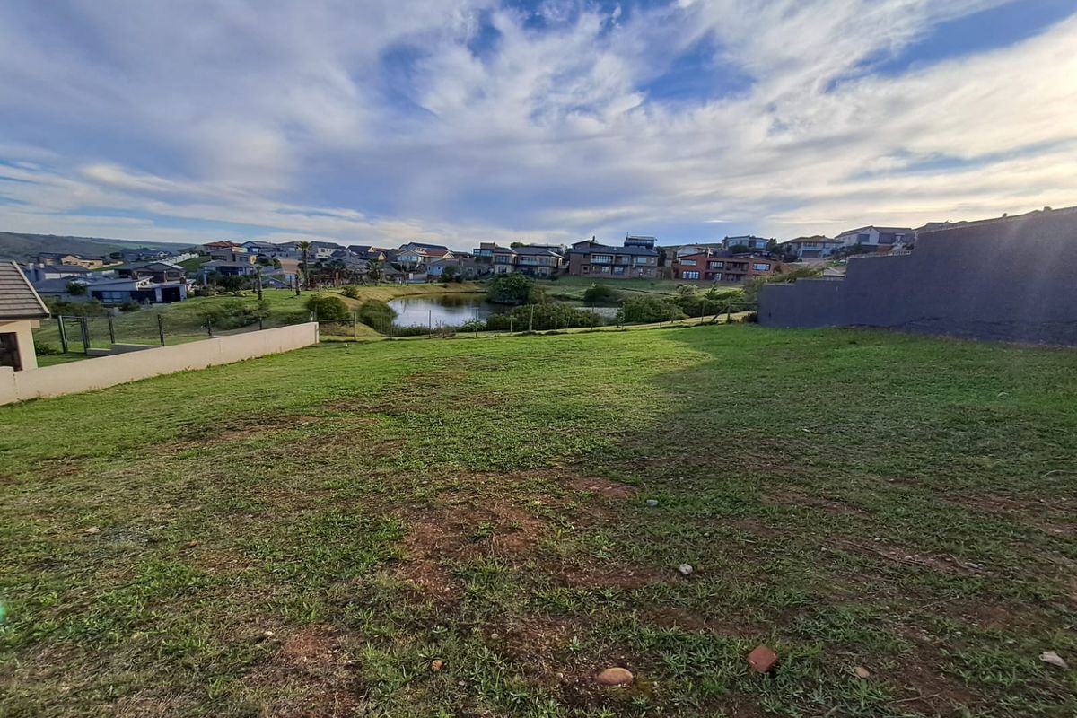A view of the vacant residential plot overlooking a small pond and the surrounding neighborhood landscape.
