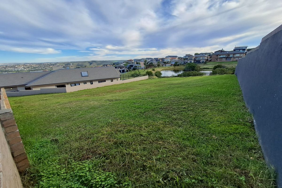 A view of the vacant residential land overlooking a pond and surrounding estate housing.
