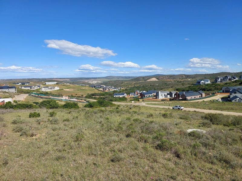 An elevated view overlooking a residential estate development with surrounding natural landscape and rolling hills.