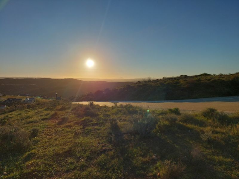 A scenic sunset view overlooking the rolling hills and landscape of the vacant residential property.