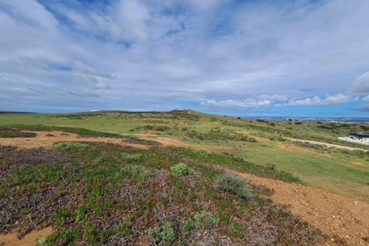 A wide-angle view of the vacant residential land, showcasing the natural coastal landscape and open terrain.