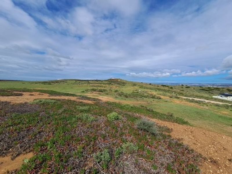 A wide-angle view of the vacant residential land, showcasing the natural coastal landscape and open terrain.